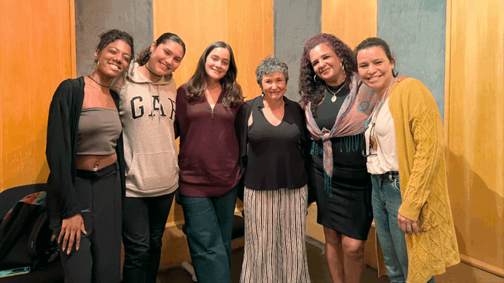 Bárbara Nascimento, do Vidigal, com a professora Nilza e estudantes no estúdio de áudio.